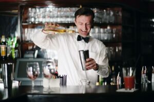 a bartender is practicing his cocktail-making skills behind the bar