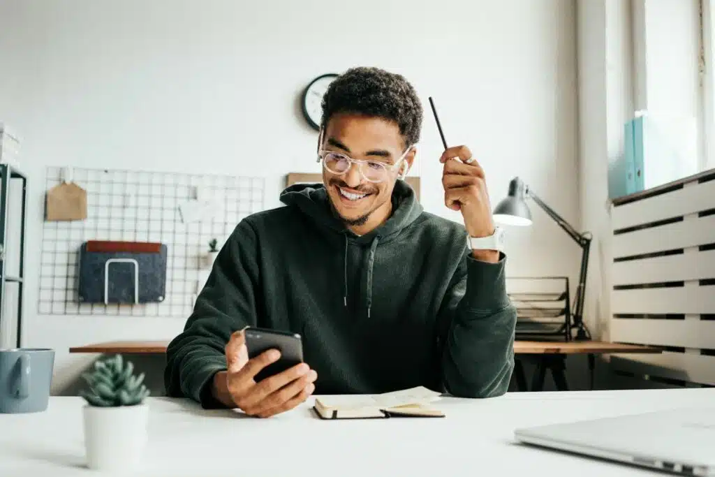 a happy young man learning from his phone