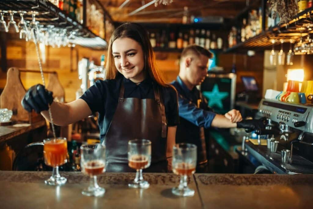 male and female bartenders working at the bar