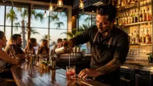 Bartender pouring a cocktail behind a wooden bar at a Florida restaurant, illustrating the Florida Responsible Vendor Program training requirement.